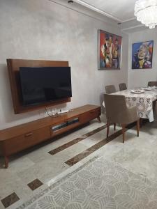 a living room with a flat screen tv and a table at hedia a monastir in Monastir