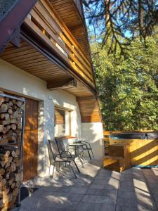a patio with chairs and a table on a house at Domek Chatka Czubatka in Bocheniec