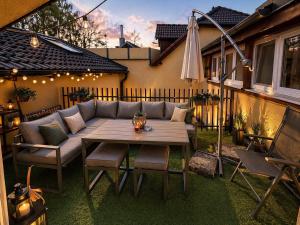 a patio with a table and chairs and an umbrella at Dům u lázní Federer in Třeboň