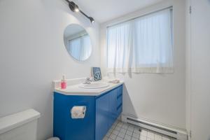 a bathroom with a blue sink and a mirror at Le loft du Hameau in Stoneham +18 photos