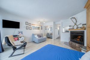 a living room with a fireplace and a blue rug at Le loft du Hameau in Stoneham