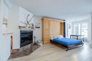 a bedroom with a bed and a fireplace at Le loft du Hameau in Stoneham