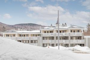 a building with snow in front of it at Le loft du Hameau in Stoneham
