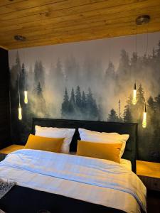 a bedroom with a bed with a forest mural on the wall at Pitoresc Cabin in Tranisu +5 photos