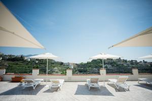 a group of chairs and umbrellas on a roof at Guesthouse with Suites on the Amalfi Coast - Residence Villa Ruocco near Amalfi - 300sqm Open Terrace near Ravello - Breathtaking View in Scala