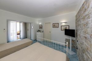 a room with a bed and a tv on a wall at Essence One by Sweet Capri in Capri