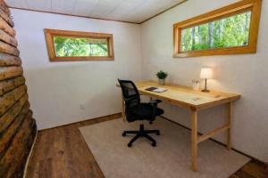 an office with a desk and a chair and two windows at Log Cabin with Mountain Views in Palmer