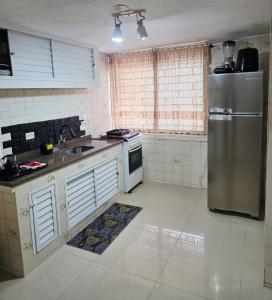a kitchen with a stainless steel refrigerator and a sink at 30 metros do mar, 2 quartos! in Pontal do Paraná