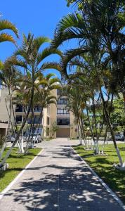 a sidewalk with palm trees in front of a building at 30 metros do mar, 2 quartos! in Pontal do Paraná
