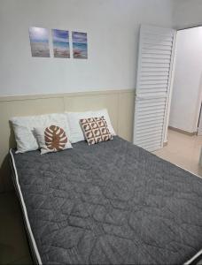 a bedroom with a large bed with pillows on it at 30 metros do mar, 2 quartos! in Pontal do Paraná