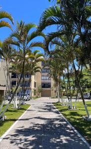 a sidewalk with palm trees in front of a building at 30 metros do mar, 2 quartos! in Pontal do Paraná