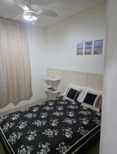 a bedroom with a bed with a black and white blanket at 30 metros do mar, 2 quartos! in Pontal do Paraná +14 photos