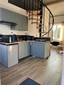 a kitchen with stainless steel appliances and a spiral staircase at Chez Raphaël et Hiba in Nesles