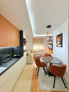a kitchen and living room with a table and chairs at Altura Garden 1 in Vrnjačka Banja
