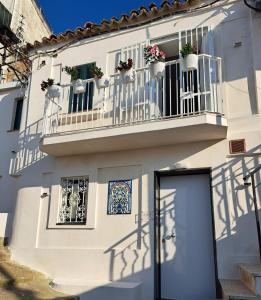 ein weißes Gebäude mit Topfpflanzen auf einem Balkon in der Unterkunft Ondablurooms2 in Pizzo