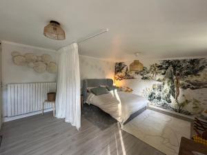 a bedroom with a bed and a painting on the wall at Le Cerisier in Giverny
