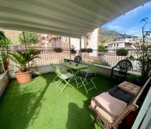a patio with a table and chairs on a balcony at Respiro Mediterraneo in Mondello