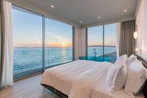 a bedroom with a large bed with a view of the ocean at Nava Star Hotel in Durrës