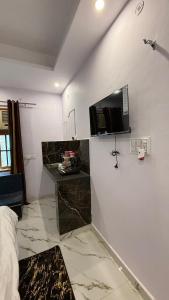 a bedroom with a tv on the wall and a bed at Indigo Inn in Malhour