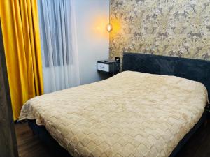 a bedroom with a bed and a yellow curtain at Green Villa in Kobuleti