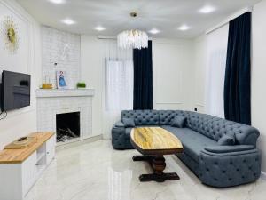 a living room with a blue couch and a table at Green Villa in Kobuleti