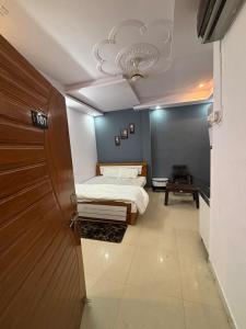 a bedroom with a bed and a wooden door at Indigo Inn in Malhour