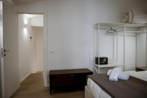 a white bedroom with a bed and a mirror at dellarocca4 in Cefalù