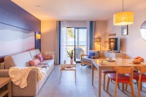 a living room with a couch and a table at Résidence Pierre & Vacances L'Archipel in Perros-Guirec