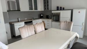 a kitchen with white cabinets and a white table and chairs at WorkHome A2 zu 6 in Lünen