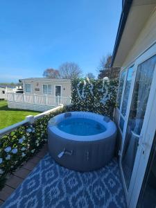 a hot tub on the patio of a house at Luxury 3 bedroom caravan hobourne Devon bay with hot tub in Goodrington