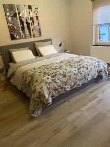 a bedroom with a large bed with a floral bedspread at B&B Pied à Pieter in Maastricht