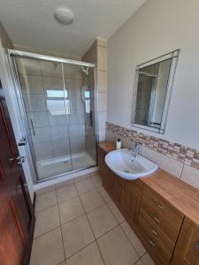 a bathroom with a sink and a shower at Quholmslie Farm Self-Catering in Stromness +6 photos
