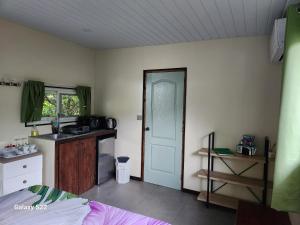 eine Küche mit Spüle und Tür in einem Zimmer in der Unterkunft Fare anuhe in Bora Bora + 14 Fotos