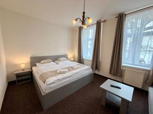a bedroom with a large bed and two windows at Hotel Zlatý Kříž in Teplice