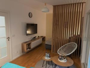 a living room with two chairs and a television at Moon apartment in Mostar