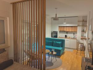 a living room with a blue couch and a kitchen at Moon apartment in Mostar