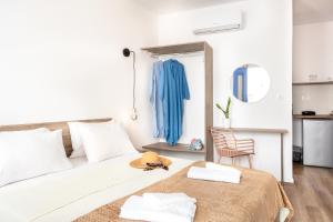 a bedroom with a bed with a hat and a chair at Twelve 12 Islands in Symi