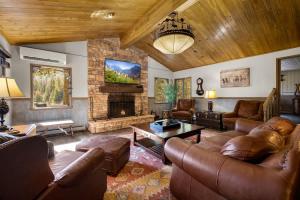 a living room with leather furniture and a fireplace at Secluded River View Hideaway in Hungry Horse
