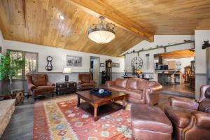 a living room with leather furniture and a wooden ceiling at Secluded River View Hideaway in Hungry Horse +56 photos