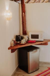 a kitchen with a counter with a microwave on a shelf at Fare Hau Lodge in Tahaa