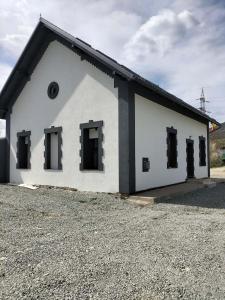 a white building with black windows on the side at Piscina Margaia in Lupşa