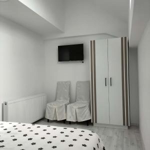 a bedroom with a bed and a cabinet and a tv at Piscina Margaia in Lupşa