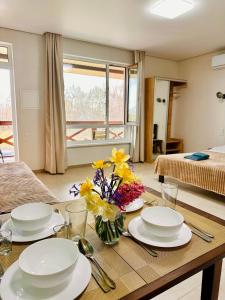 a dining room table with plates and flowers on it at Апарт-готель HAPPY in Fontanka