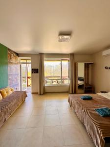 a large room with two beds and a large window at Апарт-готель HAPPY in Fontanka