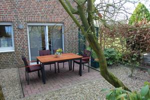 einen Holztisch und Stühle auf einer Terrasse in der Unterkunft Ferienwohnung Behner in Greven