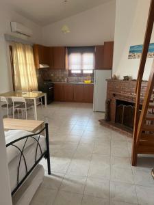 a living room with a fireplace and a kitchen at Filonoe apartment in Gialiskari