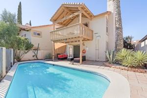 a villa with a swimming pool in front of a house at The AZ Escape in Tucson