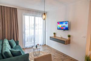 a living room with a couch and a tv on a wall at Vila Kollari in Ulcinj