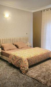 a bedroom with a bed with a flower blanket on it at Hide Out Lake Villa Uganda in Bwerenga +28 photos