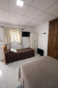 a hotel room with two beds and a window at Hospedaje Don Felix in General Acha